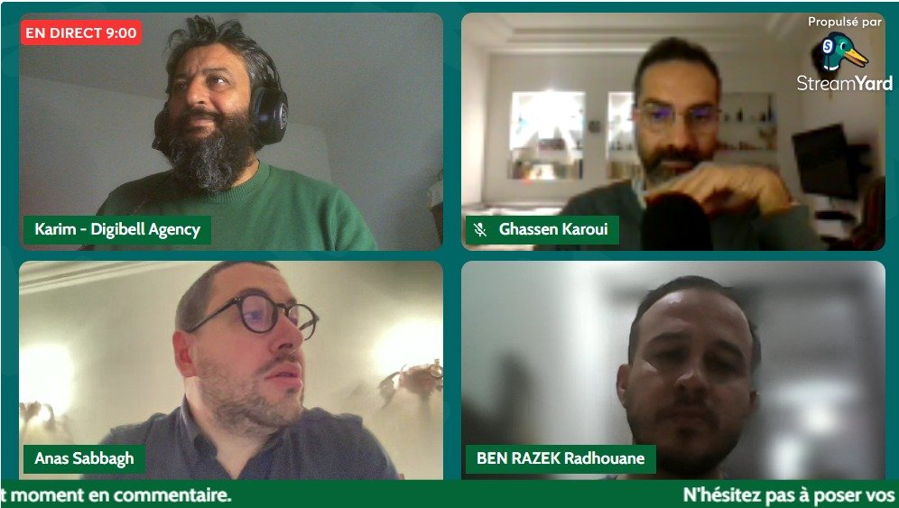 Quatre personnes en visioconférence, discutant sur une plateforme numérique, avec des expressions variées.